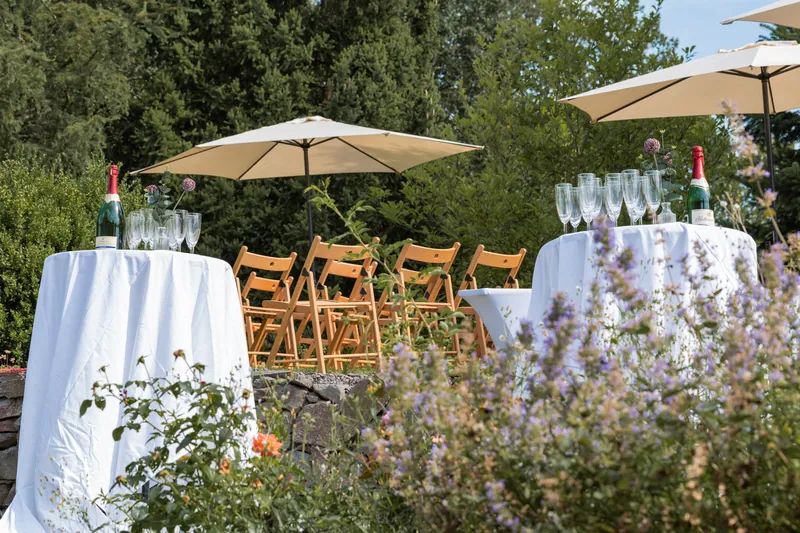 Stehtische mit Sonnenschirmen im Garten